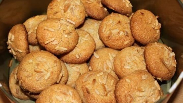 Kleine, runde Amaretti morbidi Kekse liegen &uuml;bereinander in einer silbernen Sch&uuml;ssel und zeigen eine goldene, leicht gebr&auml;unte Oberfl&auml;che.