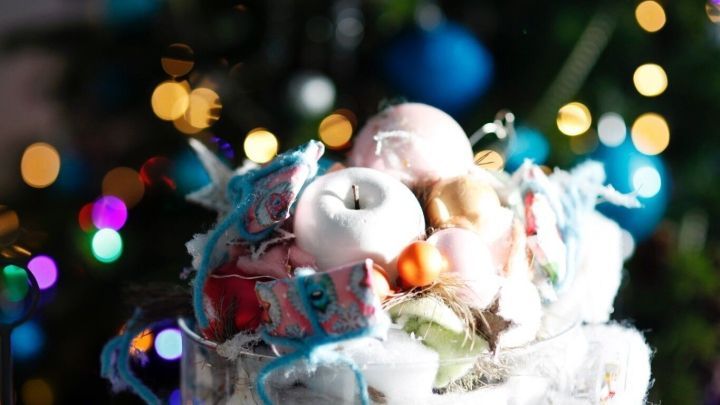 &Auml;pfel in einem festlichen Arrangement, umgeben von bunten Dekorationen, setzen einen herbstlichen Akzent.