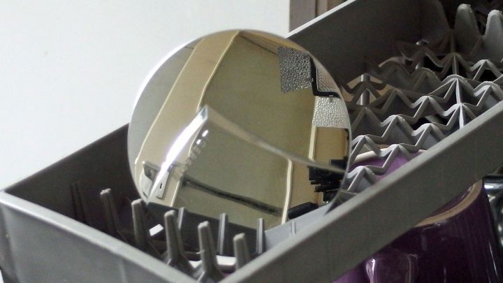 Ein gl&auml;nzender Waschbeckenst&ouml;psel liegt im oberen Bereich eines Geschirrsp&uuml;lers, um effektiv gereinigt zu werden.