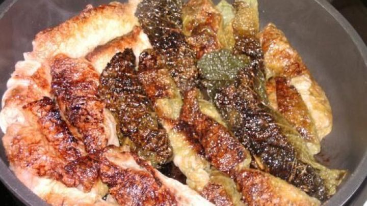 Kohlrouladen brutzeln in einer Pfanne, die R&ouml;staromen betonen die gebr&auml;unte Oberfl&auml;che und verleihen ihnen zus&auml;tzliche W&uuml;rze.