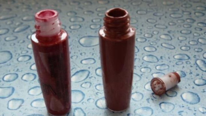 Zwei Lippenstifte stehen auf einer glatten, feuchten Oberfl&auml;che, einer ist leer, w&auml;hrend der andere noch unbenutzt ist.