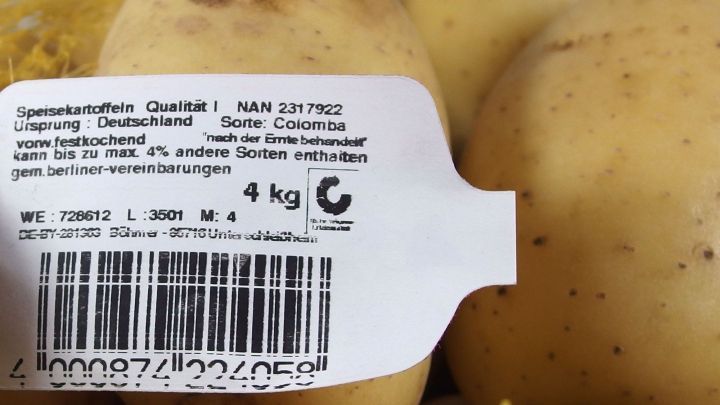 Kartoffeln mit einem Etikett liegen zusammen auf einem Haufen, bereit zum Verkauf im Supermarkt.