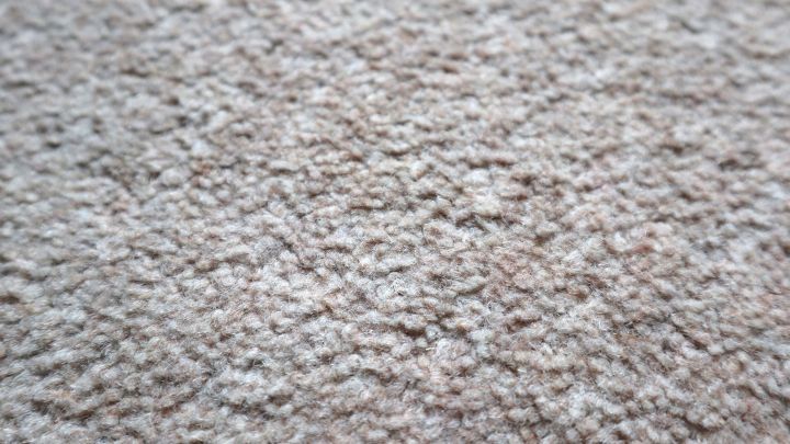 Teppich mit beige-brauner Textur, ruhig und unber&uuml;hrt, liegt in geschlossener Umgebung ohne sichtbare Flecken.