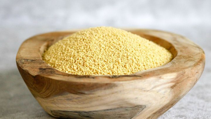 Eine Holzschale enth&auml;lt gelblichen Couscous, der als alternative Zutat zum Paniermehl dient.