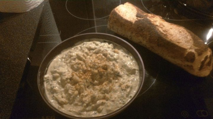 Eine Sch&uuml;ssel mit Eierdipp steht auf der Arbeitsplatte, w&auml;hrend daneben ein frisches St&uuml;ck Brot liegt.