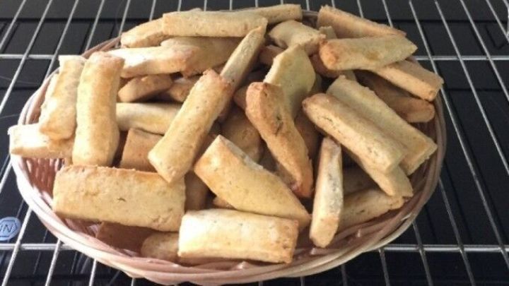 Goldbraune "Totenbeinle" liegen auf einem Teller und k&uuml;hlen auf einem Gitterrost in einer modernen K&uuml;che.