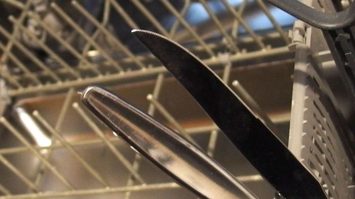 Schneidmesser stehen im Geschirrsp&uuml;ler, gef&auml;hrlich positioniert zwischen dem Geschirr und dem Besteckkorb.