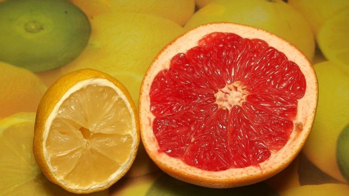 Zwei geschnittene Zitrusfr&uuml;chte liegen auf einer gelben Unterlage, die frischen Duft in den Raum bringt.