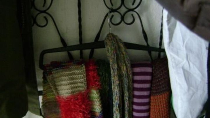 Ein Handtuchhalter bietet Platz f&uuml;r mehrere bunte Schals, die ordentlich aufgereiht sind, in einer abwechslungsreichen Garderobe.