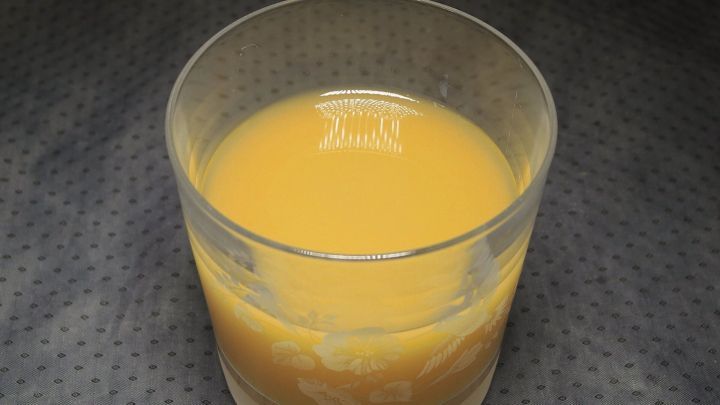 Ein Glas naturtr&uuml;ber Apfelsaft steht auf einem dunklen Stoff, bereit, gegen Verstopfung zu helfen.