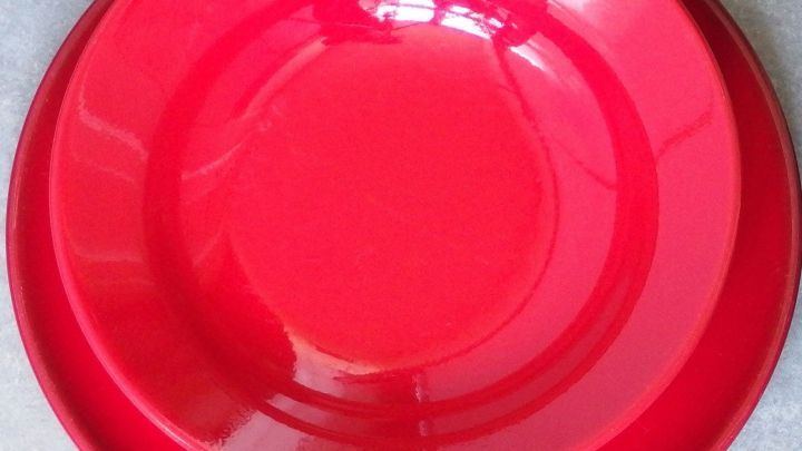 Ein gl&auml;nzender, roter Teller liegt auf einer hellen Oberfl&auml;che und strahlt Sauberkeit und frische beim Geschirr ab.