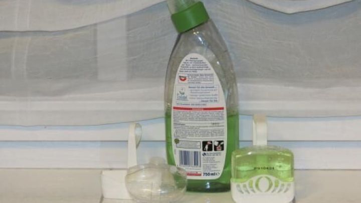 Ein WC-Sp&uuml;ler steht auf einem Fensterbrett, umgeben von einem Sp&uuml;lmittel und einer Seifenschale, im nat&uuml;rlichen Licht.