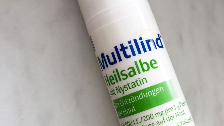 Eine Tube Multilind Heilsalbe steht auf einer hellen Oberfl&auml;che und wird zur Behandlung von Babypo-Eentz&uuml;ndungen verwendet.