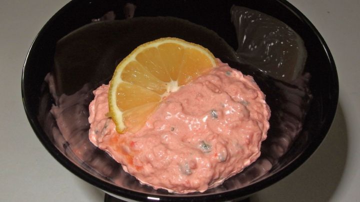 Eine Lachscreme mit einer Zitronenscheibe auf einem schwarzen Teller, serviert in einer modernen K&uuml;chensoftware.