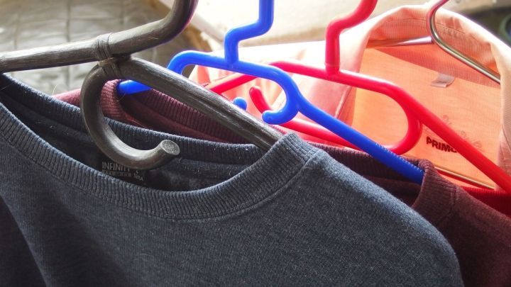 Bunte Kleiderb&uuml;gel halten W&auml;sche auf, w&auml;hrend sie in einem hellen Raum auf einer glatten Fl&auml;che zum Trocknen bereitstehen.