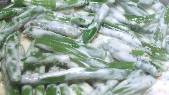 Gr&uuml;ne Bohnen liegen in einer wei&szlig;en, cremigen Sauce und sind zubereitet, um die Gefahren von rohen Bohnen zu vermeiden.