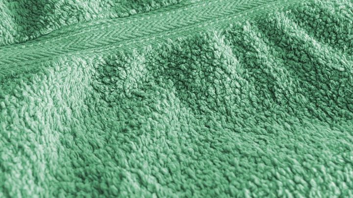 Gr&uuml;ne Handt&uuml;cher liegen unsortiert auf einer Fl&auml;che, die Struktur zeigt eine flauschige, saugf&auml;hige Oberfl&auml;che an.