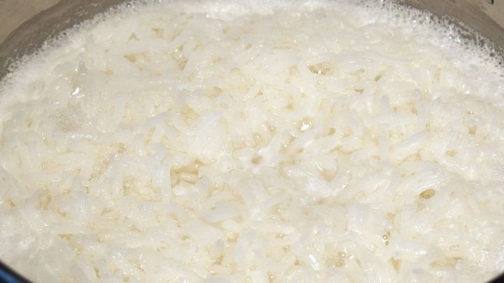 Reis kocht im Topf, sprudelt leicht und ist bereit f&uuml;r die Zubereitung von Gerichten im heimischen K&uuml;chenumfeld.