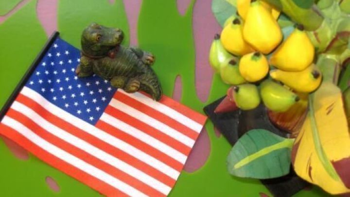 Eine kleine Statue sitzt auf der US-Flagge, umgeben von gelben Fruchtschalen, die eine einladende Atmosph&auml;re schaffen.