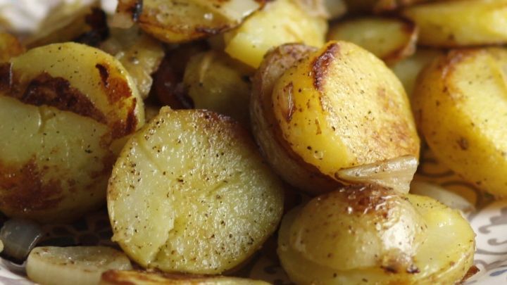 Knusprige Ofenkartoffeln liegen auf einem Teller und gl&auml;nzen leicht, w&auml;hrend sie goldbraun und appetitlich angerichtet sind.