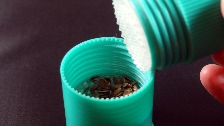 Ein gr&uuml;ner Tabletten-Zerkleinerer wird ge&ouml;ffnet, um Gew&uuml;rze einzuf&uuml;llen; er steht auf einem schwarzen Untergrund.