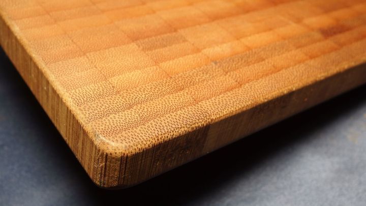 Ein Holzbrett liegt auf einer dunklen Oberfl&auml;che, w&auml;hrend Wasserdampf es gerade macht und die Struktur verbessert.