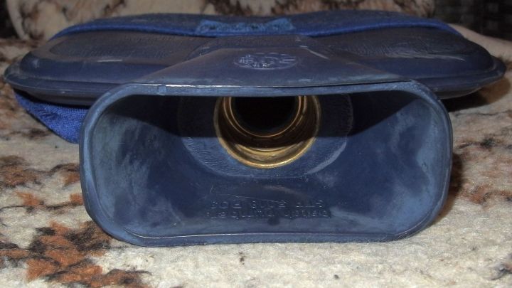 Eine blaue W&auml;rmflasche liegt auf einem Teppich, ge&ouml;ffnet, bereit zum Bef&uuml;llen mit hei&szlig;em Wasser f&uuml;r entspannende W&auml;rme.