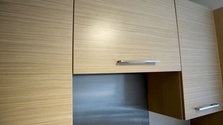 Helle K&uuml;chenschr&auml;nke sind sauber und gepflegt, w&auml;hrend Fettflecken auf der Oberfl&auml;che vermieden werden.