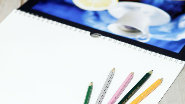 Ein Malpapier liegt auf einem Tisch, w&auml;hrend bunte Buntstifte bereitstehen, um kreative Bastelideen zu verwirklichen.