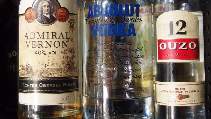 Drei Flaschen alkoholischer Getr&auml;nke stehen nebeneinander: Admiral Vernon, Absolut Vodka und Ouzo, was auf eine Cocktailparty hindeutet.