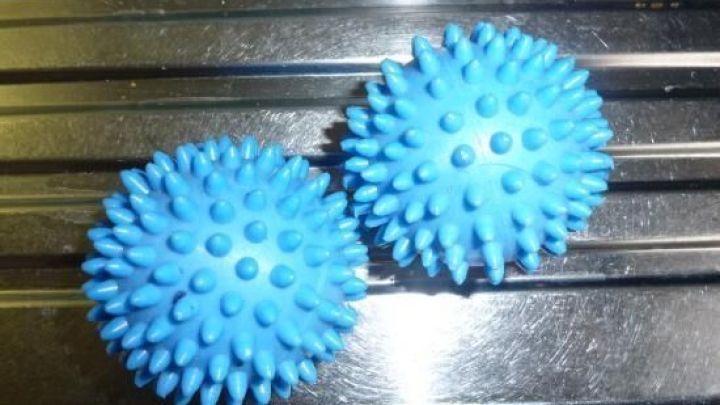 Zwei blaue W&auml;scheigel liegen auf einem metallischen Untergrund, bereit f&uuml;r eine Massageanwendung zur Entspannung.