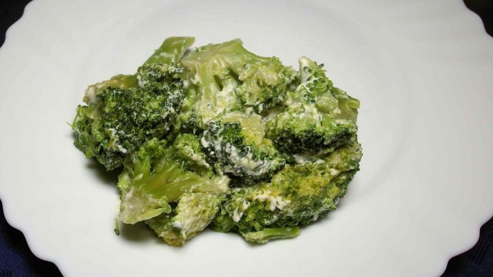 Gekochter Brokkoli auf einem wei&szlig;en Teller, schonend zubereitet in der Mikrowelle, um frische Vitamine zu erhalten.