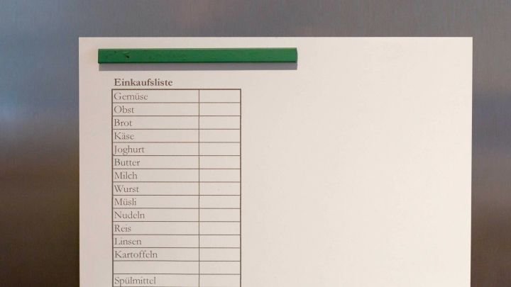 Eine Einkaufsliste aus dem PC h&auml;ngt an einem K&uuml;hlschrank und zeigt verschiedene Artikel, die eingekauft werden sollen.