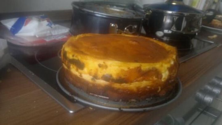 Ein leckerer Eierschecke-Kuchen steht auf der Arbeitsfl&auml;che, umgeben von T&ouml;pfen und schmackhaften Zutaten in einer K&uuml;che.