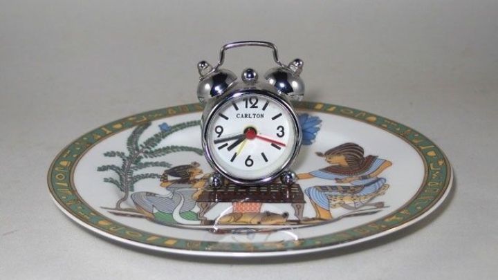 Ein Wecker steht auf einem dekorativen Teller und symbolisiert einen Trick, um Schlafm&uuml;tzen vor dem Verschlafen zu retten.