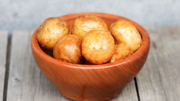 Sch&uuml;ssel Pellkartoffeln steht ruhig auf einem Holztisch, bereit zum Sch&auml;len.