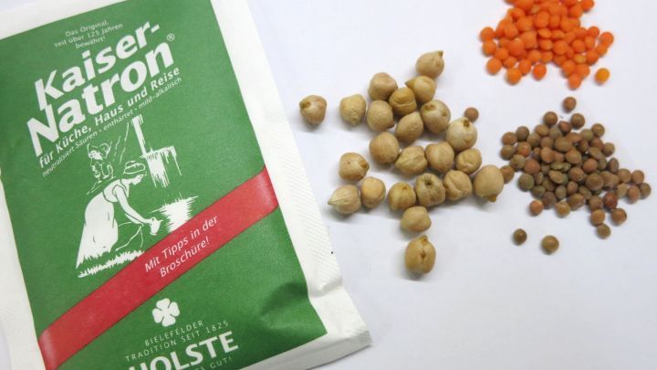 Eine Packung Kaiser-Natron liegt neben verschiedenen H&uuml;lsenfr&uuml;chten, die zum Kochen vorbereitet sind.