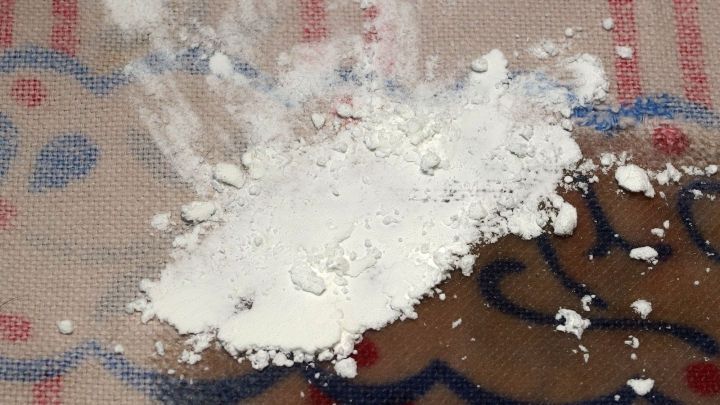 Wei&szlig;e Substanz liegt verstreut auf einer gemusterten Oberfl&auml;che, die als Untergrund f&uuml;r die Entfernung von Fettflecken dienen k&ouml;nnte.