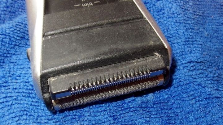 Ein Rasierer liegt auf einem blauen Handtuch, bereit zur Anwendung, um Rasurbrand mit Vaseline zu vermeiden.