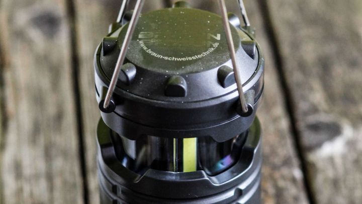 Ein schwarzes Solarlicht steht auf einer Holzoberfl&auml;che und strahlt sanftes Licht aus, w&auml;hrend es die Umgebung beleuchtet.