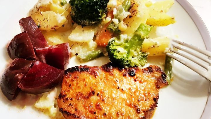 Ein gebratenes St&uuml;ck Fleisch liegt neben roten Beete und einem bunten Gem&uuml;semix auf einem Teller.