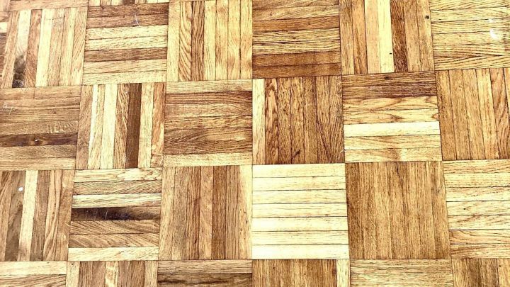 Ein Parkettboden zeigt verschiedene Holzmaserungen. Der Boden steht in einem Innenraum und wirkt gepflegt und hell.