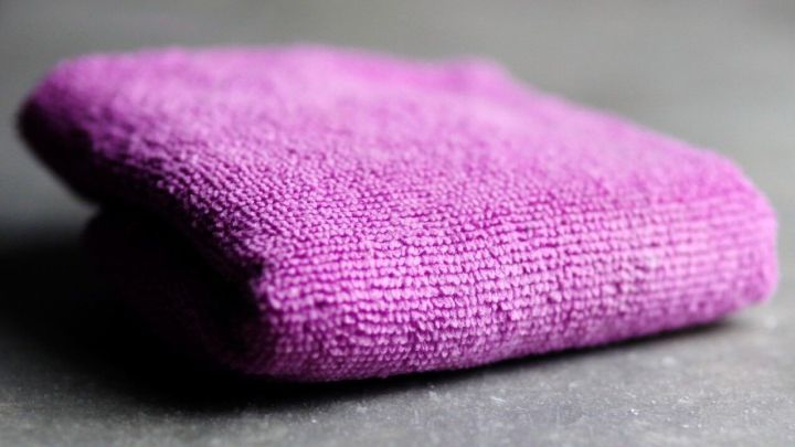 Ein lila Putzlappen liegt auf einer grauen Oberfl&auml;che und wartet darauf, zur Bek&auml;mpfung von &uuml;bel riechender Kochw&auml;sche verwendet zu werden.