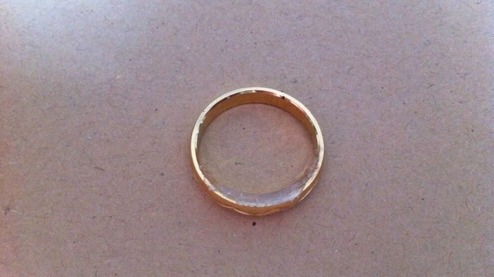 Der Ring liegt auf einer hellen Oberfl&auml;che und wird vermutlich mit Hei&szlig;kleber verkleinert, um besser zu passen.