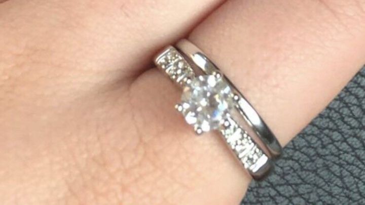 Ein gl&auml;nzender Ring mit Fimo sitzt auf einem Finger, umgeben von einer strukturierten Unterlage, der Hand ist ruhig.