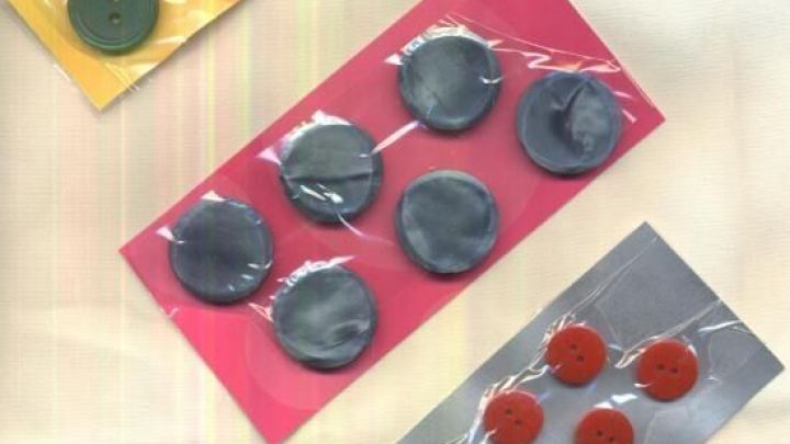 Mehrere Karten mit Kn&ouml;pfen sind ordentlich verpackt und auf einem hellen Hintergrund angeordnet.