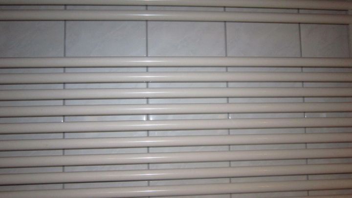 Ein Handtuchhalter mit horizontalen R&ouml;hren ist sauber und ordentlich an einer Wand montiert, bereit zur Nutzung.