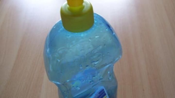 Eine Klarsp&uuml;lerflasche wird auf einem Tisch gezeigt, bereit zum gezielten Gie&szlig;en von Topfblumen.
