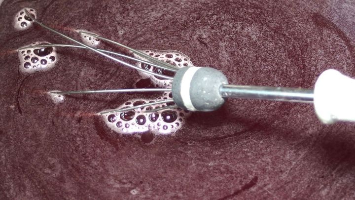 Ein R&uuml;hrger&auml;t mischt dunklen Fruchtsaft in einer Sch&uuml;ssel, w&auml;hrend Blasen entstehen &ndash; ideal zum Gelee selber machen.