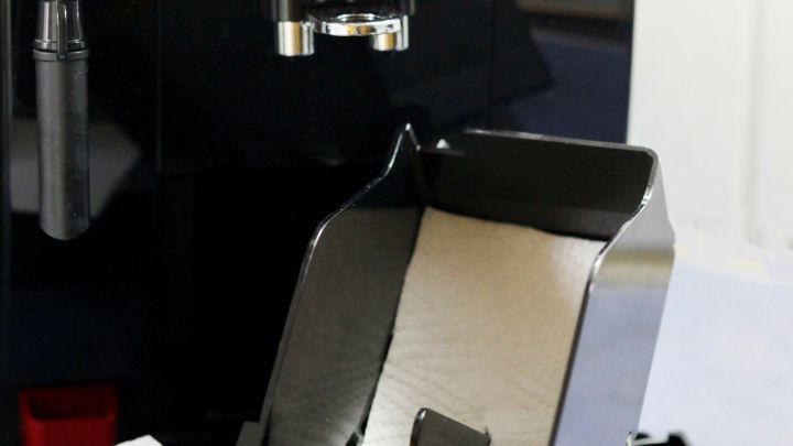 Ein Kaffeevollautomat steht in einer K&uuml;che. Der Tresterfach ist herausgenommen und mit K&uuml;chenpapier ausgelegt, um sauber zu bleiben.